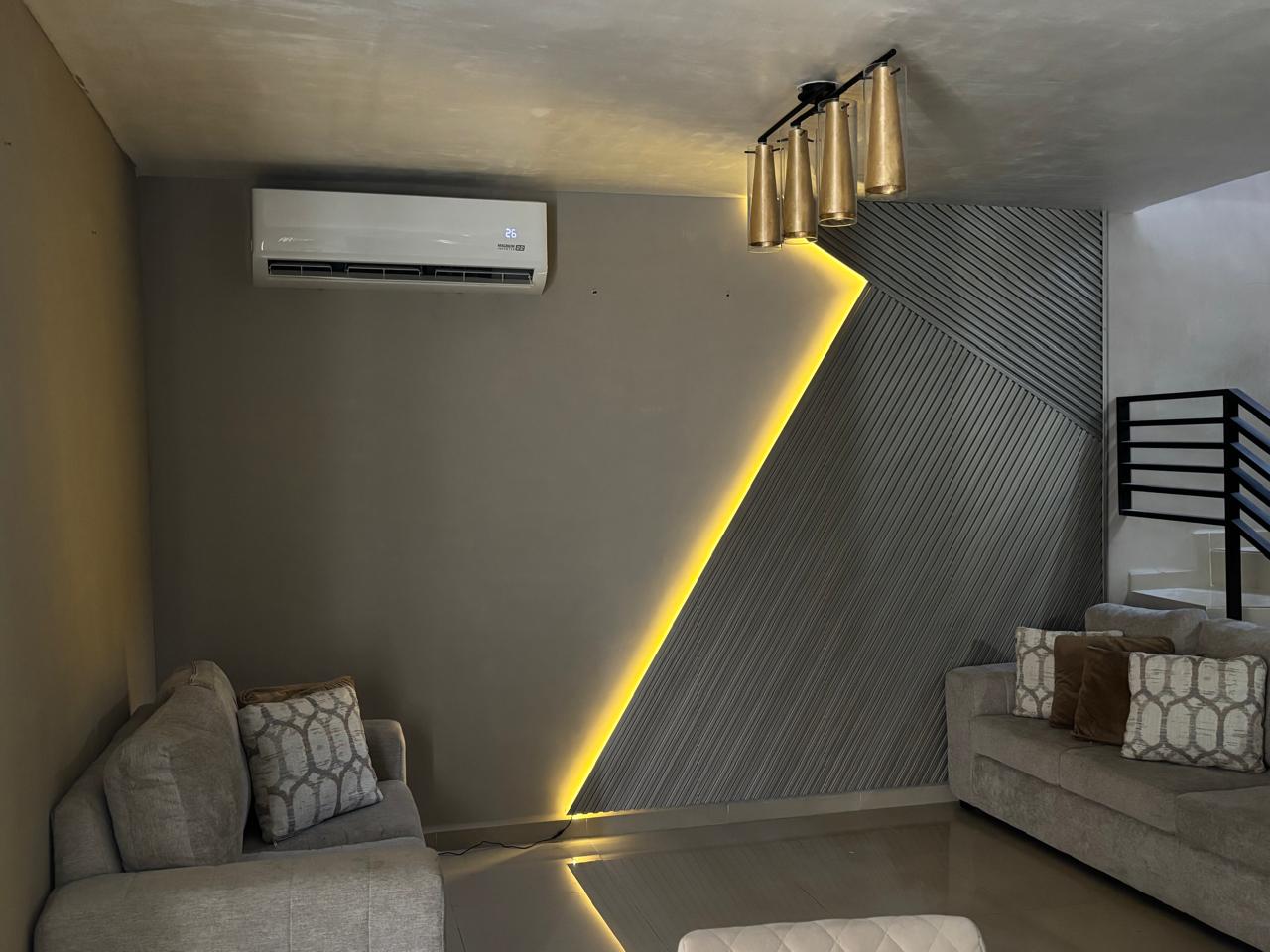 Después: sala renovada con muro de lambrín e iluminación LED integrada