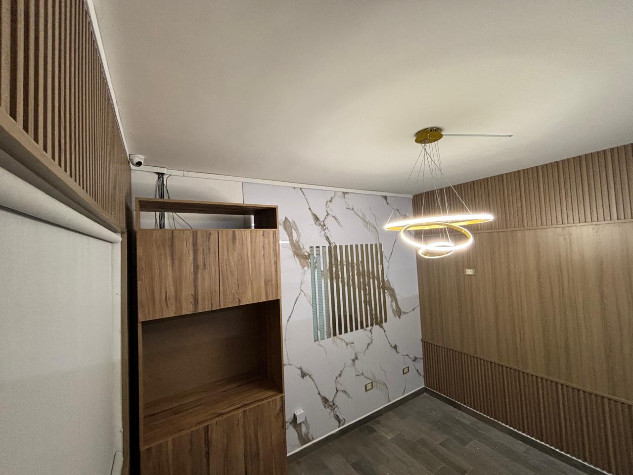 Sala contemporánea con carpintería, lambrín y acabado tipo mármol
